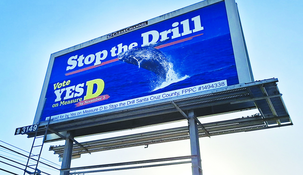 Blue billboard featuring a breaching whale reads “Stop the Drill” and urges a yes vote on Measure D by November 3.