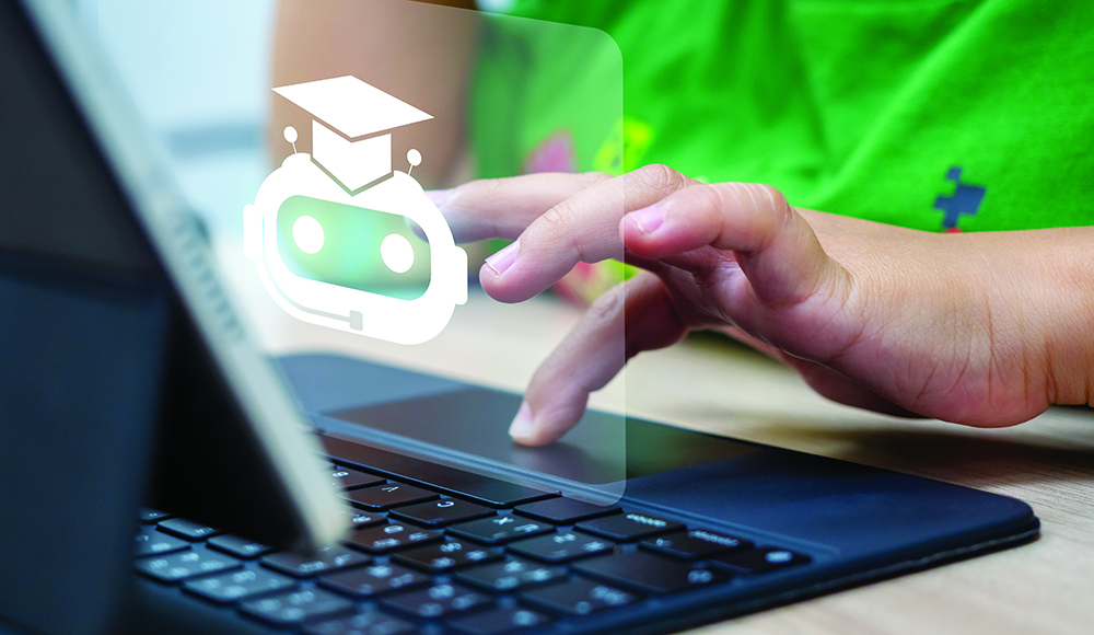 A hand uses a laptop touchpad beneath an overlaid chatbot icon wearing a graduation cap.