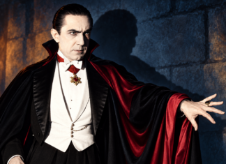The Editor’s Desk Color illustration of Bela Lugosi as Dracula, wearing a black and crimson cape with one hand outstretched.